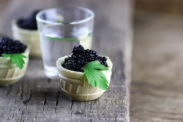 Black caviar on a wooden background