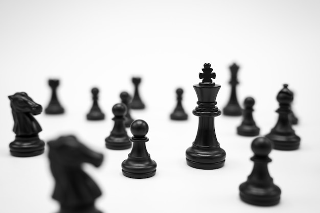 черные шахматные фигуры на белой поверхности