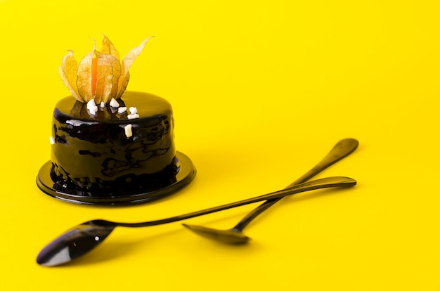 Black chocolate cake topped with black velvet icing decorated with physalis.