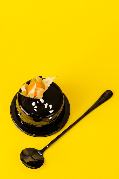 벨벳 장식을 얹고 노란색에 physalis로 장식 된 블랙 초콜릿 케이크