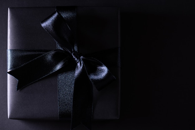 Black Christmas box on black  with copyspace, Black Friday.