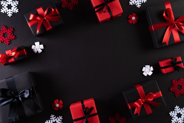 Black Christmas boxes with red ribbon on black 