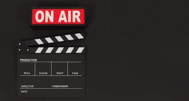 Black clapperboard or movie slate and on air on black background