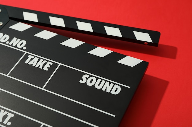 Black clapperboard on red background