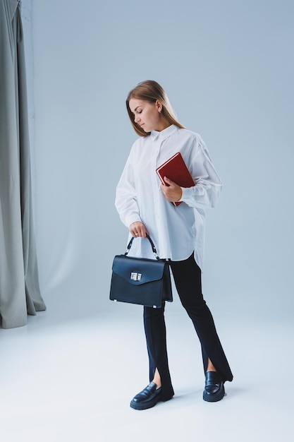 Black classic leather bag in a girl's hand Woman with luxury bag