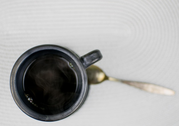 Black clay cup with hot coffee