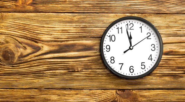 Black clock on wooden background. Top view.