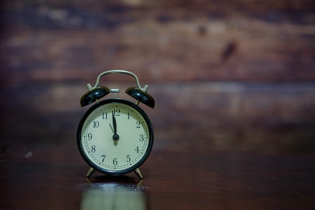 Photo the black clock on wooden.