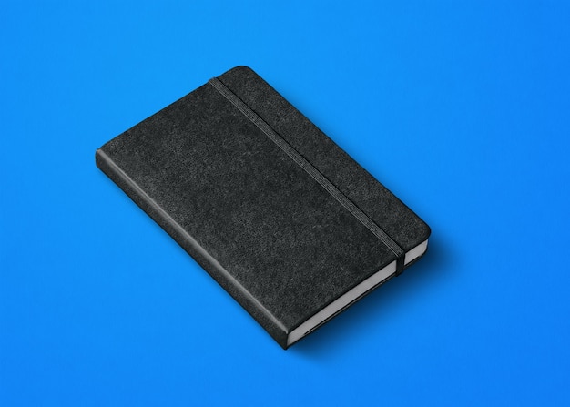 Black closed notebook mockup isolated on blue