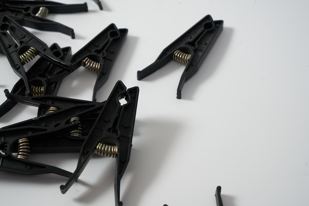 Black clothes pegs on a white background