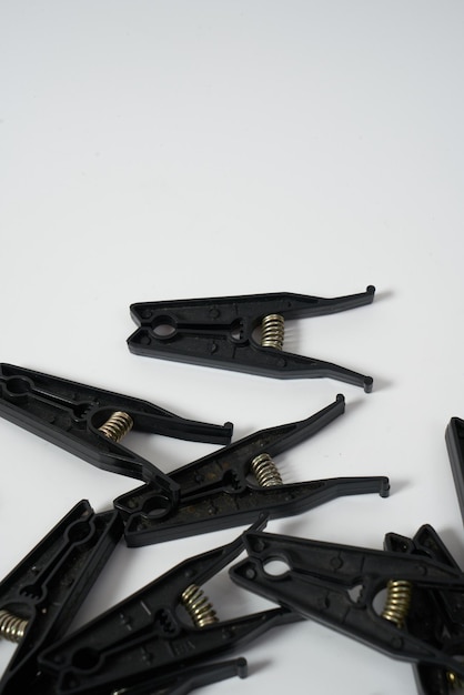 Black clothes pegs on a white background