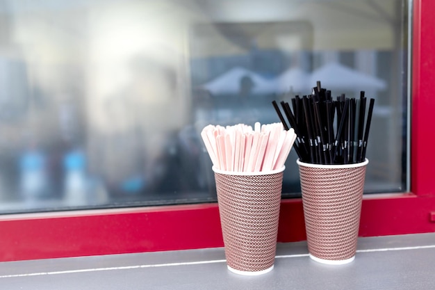 Black cocktail tubes with corrugation wooden stirring sticks in paper cups
