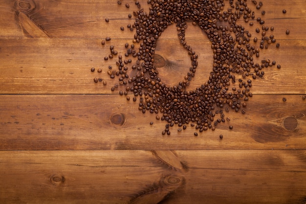 Chicchi di caffè nero sulla tavola di legno marrone