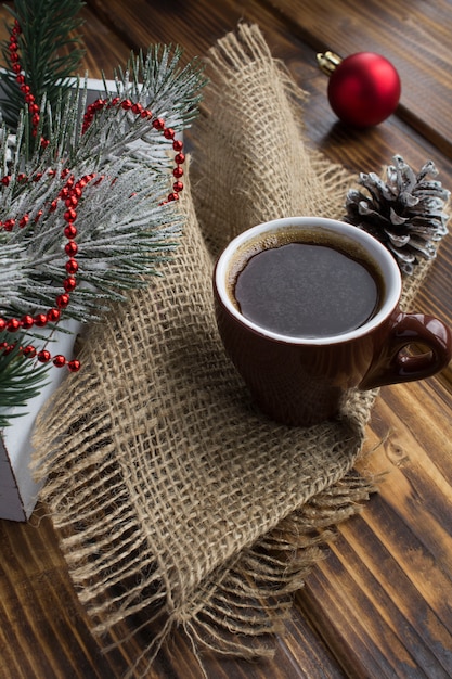 Black coffee in the brown ceramic cup and Christmas composition