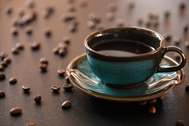 black coffee and coffee bean On the black table Top view