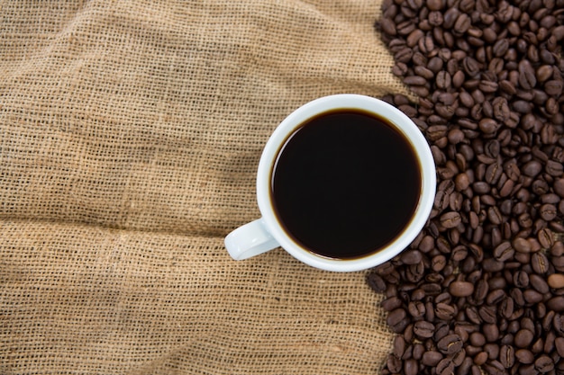 Черный кофе и кофейные зерна на мешке