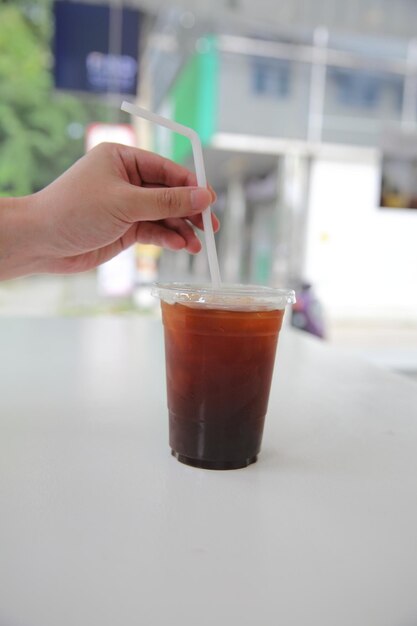 Black coffee in coffee paper cup in white tone coffeeshop