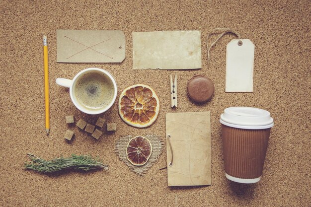 砂糖、カード、茶色のテーブルの背景にバッグとカップのブラックコーヒー