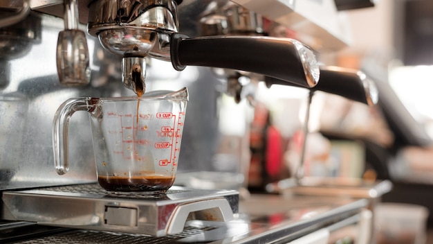 black coffee in measuring cup put on coffee maker