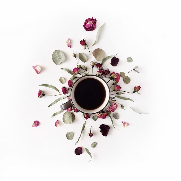 Black coffee mug and red rose buds bouquet with eucalyptus on white