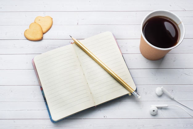 Caffè nero in un bicchiere di carta e biscotti a forma di cuori