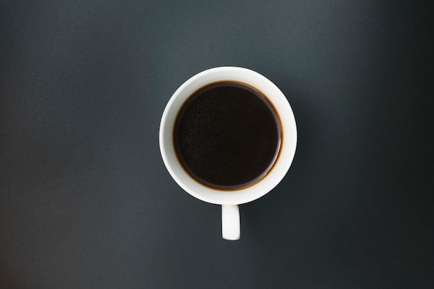 Black coffee poured into a porcelain coffee cup on a black background