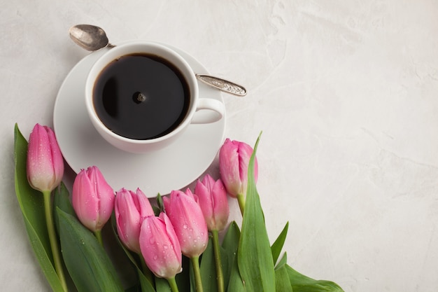 Black coffee in white Cup and tulips.