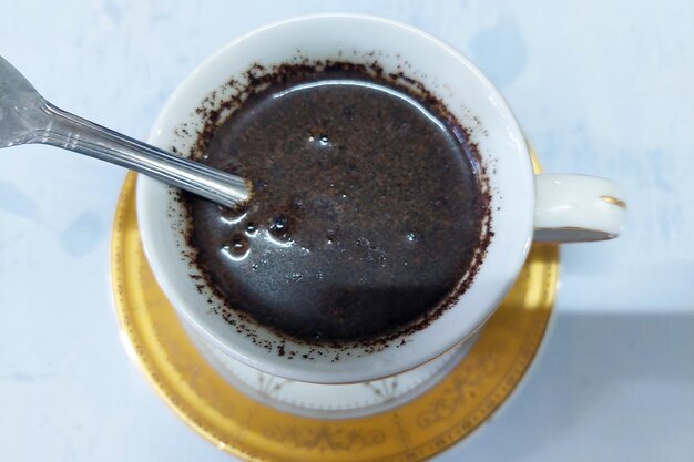 black coffee in a white glass on a white table ready to drink