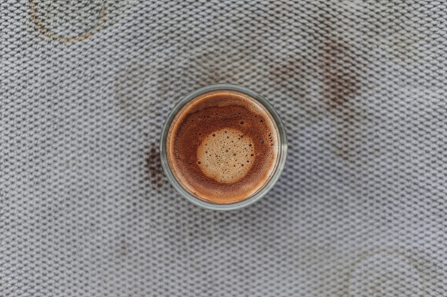 Black coffee with beautiful crema on dirty grey cloth