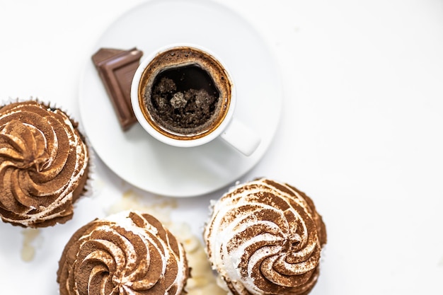 Black coffee with cupcakes and muffins Spice cupcakes with creamcheese frosting decorated with a cocoa