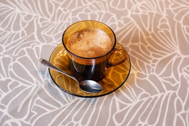 Black coffee with foam in a Duralex mug. Duralex cup and saucer.