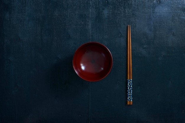 Black color wooden table top view On the table are the Japanese wooden chopsticks bowl