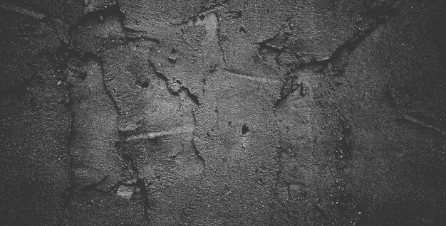 Black concrete wall or dark gray rough grainy stone texture background