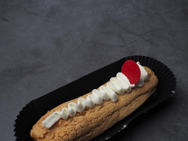 A black container with a banana and whipped cream on it