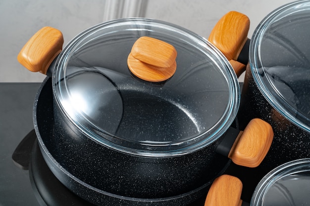 Black cookware on induction stove against grey wall