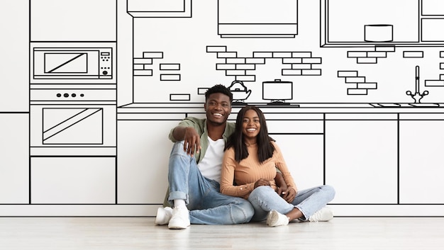 Black couple hugging near white wall with drawn kitchen interior