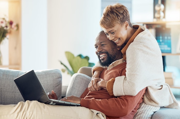 Black couple laptop and hug together with technology at home watching a film or video call with 5g network Black man black woman and spending quality time on sofa connection and streaming online
