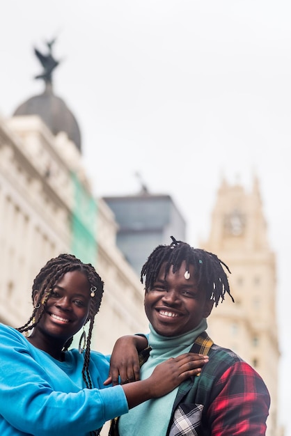 Photo black couple in love, in the city. looking at camera smiling.