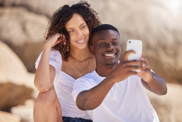 Black couple selfie and beach with a woman and man together taking a social media profile picture Love care and summer travel of young people outdoor with freedom on a holiday with happiness