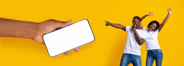 Black couple showing blank empty smartphone screen for mockup