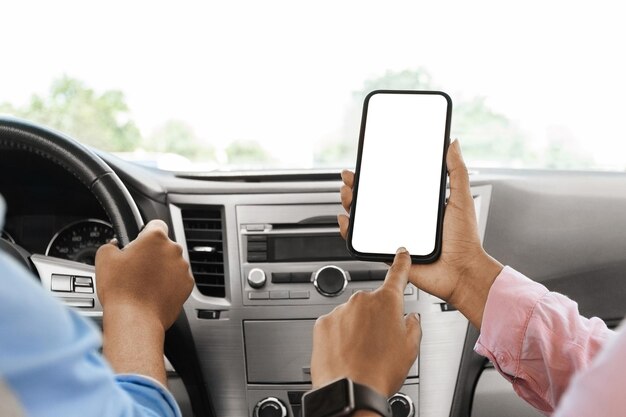 Black couple using smartphone with empty screen in car