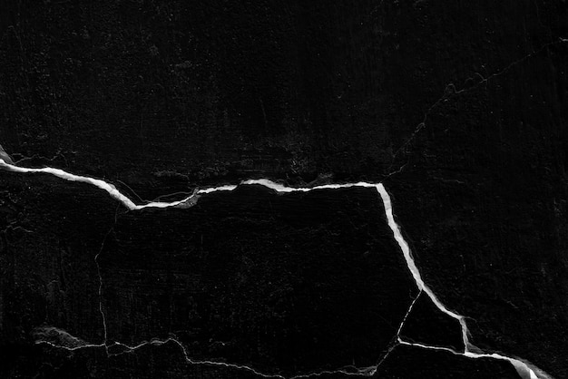 Black cracked wall with large crack, background or texture