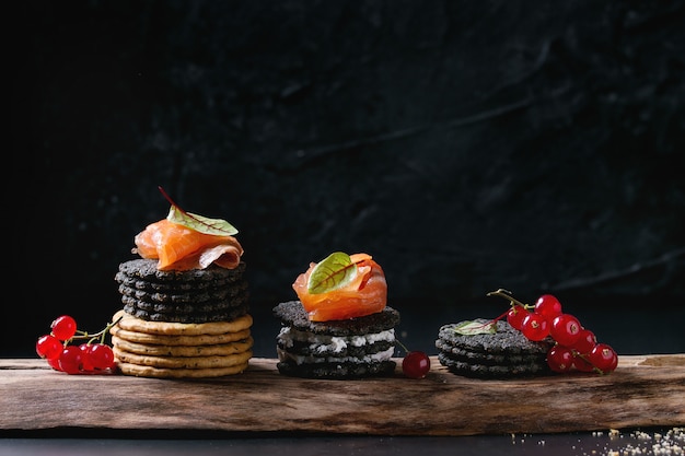 Black crackers with salmon and berries