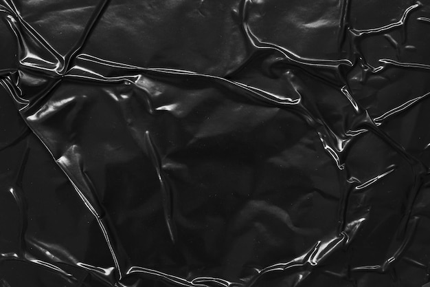 Foto fondo di struttura del manifesto di plastica sgualcito e piegato nero