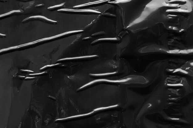 Black crumpled and creased plastic poster texture background