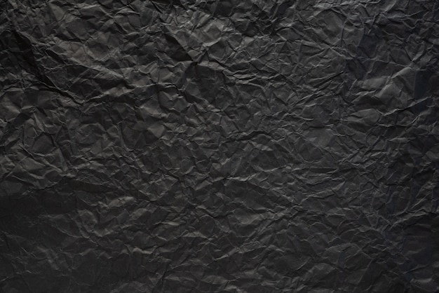 Black crumpled paper texture background. 
