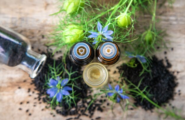 Foto olio di cumino nero in bottiglia. messa a fuoco selettiva.