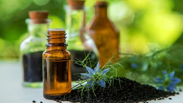 Black cumin oil in a bottle. Selective focus.