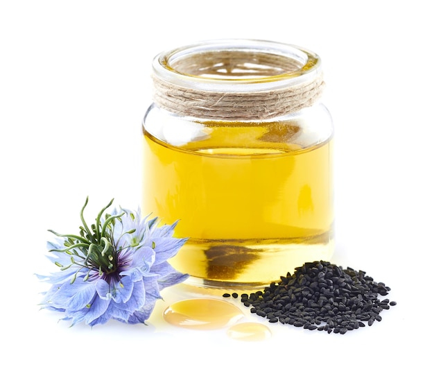 Black cumin oil with nigella sativa flower in closeup on white background