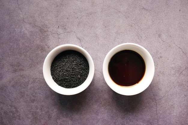 Black Cumin oils in a container on black background